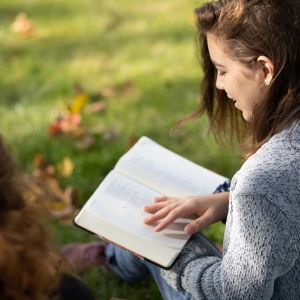 Emmaus student reading Bible on lawn