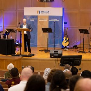 Man Speaking on Stage at Conference