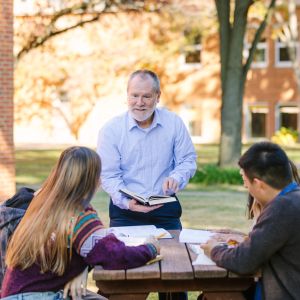 Bible faculty outdoors with students