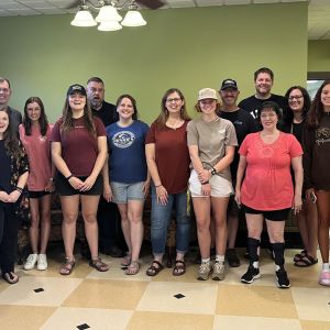 A group of men and women stand in a coffee shop
