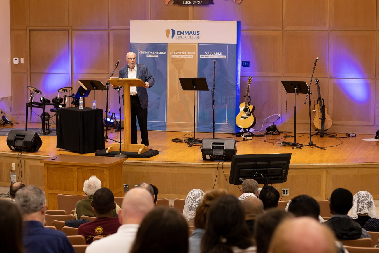 Man Speaking on Stage at Conference